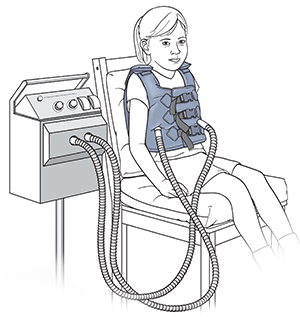 Girl sitting in chair wearing vibrating vest.
